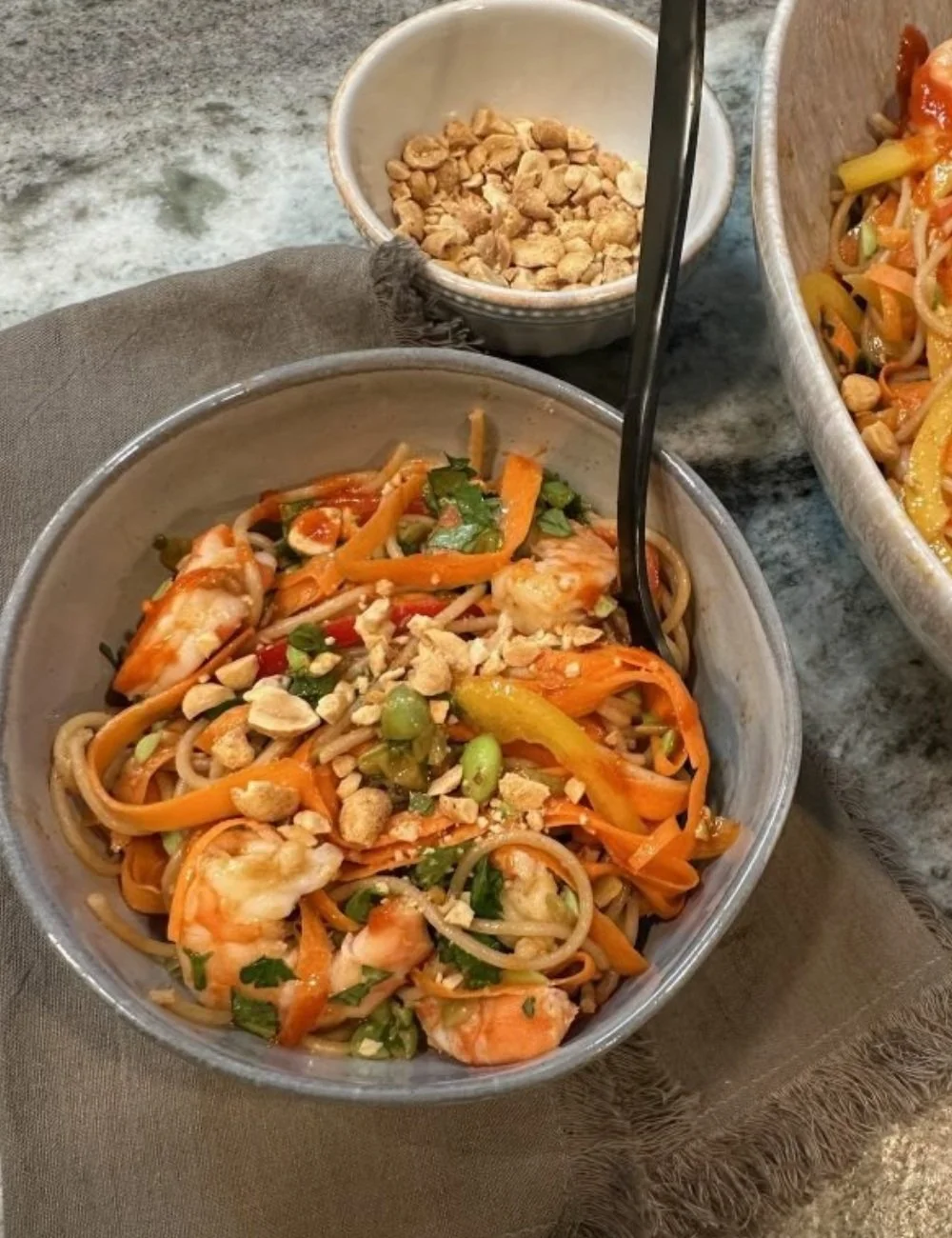 A delicious plate of Spaghetti Pad Thai garnished with herbs and lime.