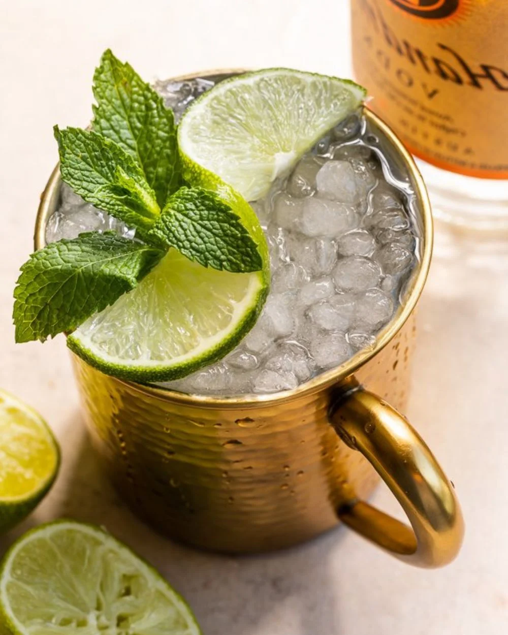 A refreshing Moscow Mule cocktail served in a copper mug with lime and mint garnish.