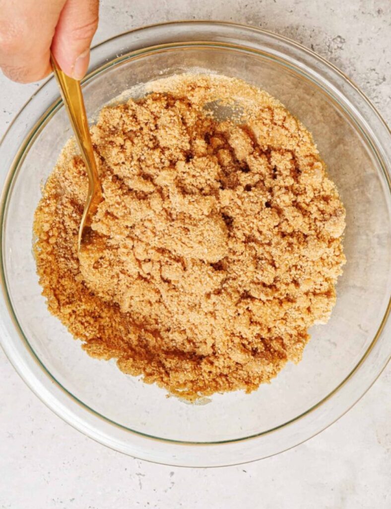 A close-up of a hand whisking batter in a bowl, showcasing the blending process and creamy consistency of the mixture.