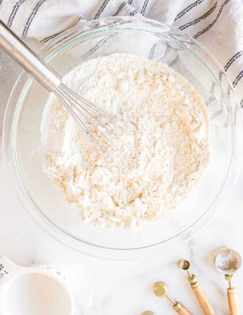 In a mixing bowl, combine the flour, baking powder, and salt. Stir well to ensure the baking powder is evenly distributed throughout the flour.