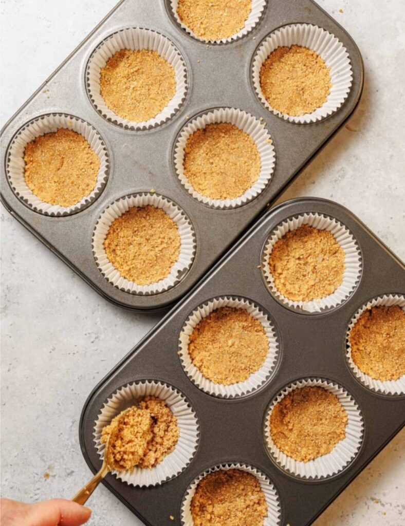 A muffin pan with a spoon resting in the center, ready for baking or mixing ingredients.