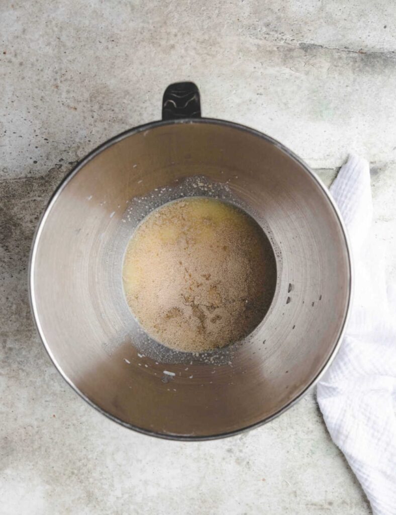 2. A metal bowl containing liquid is placed beside a neatly arranged white towel.
