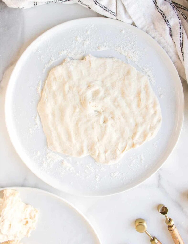 Divide the rested dough into small balls, then flatten each ball to about 1/4 inch thick.