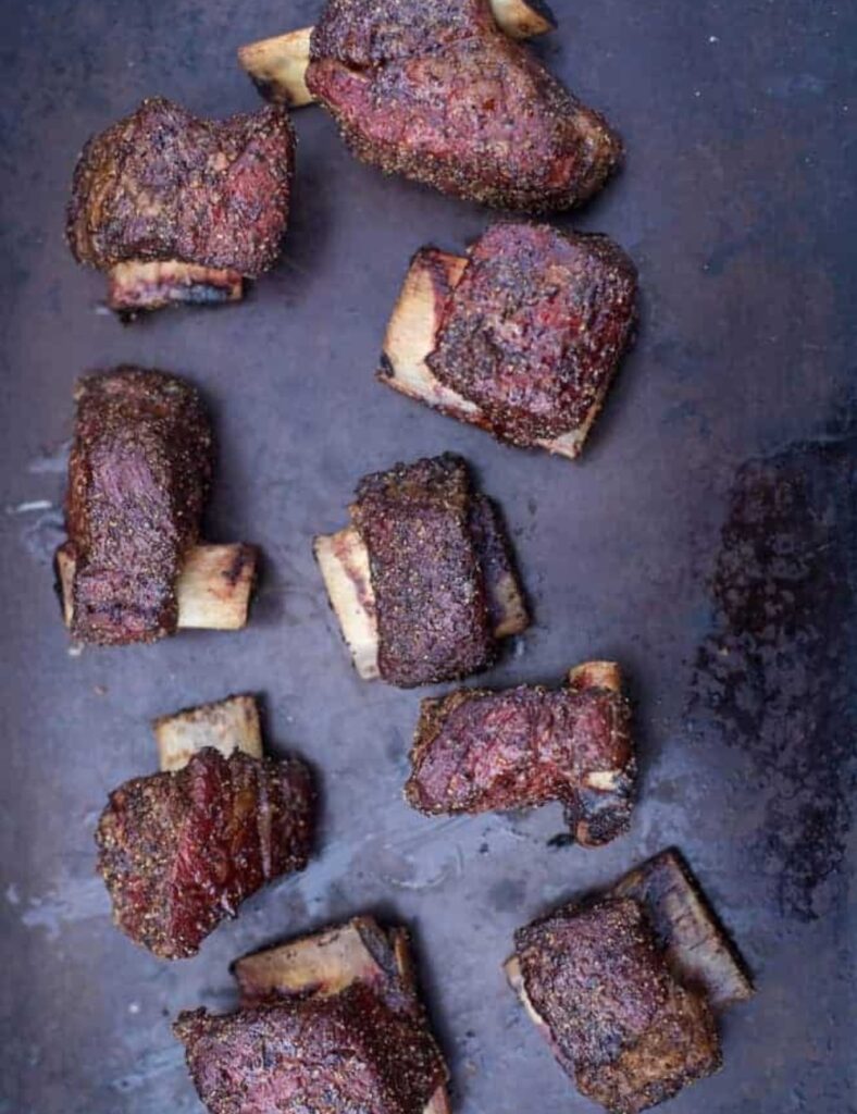 Deliciously smoked beef short ribs on a grill, ready for serving.