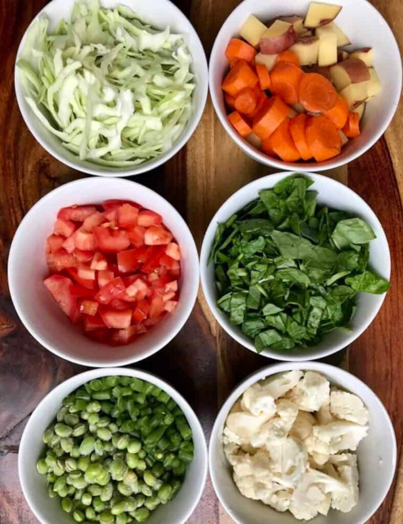 1 cup rice, 
1 cup split moong dal (yellow lentils), 
2-3 cups mixed vegetables (carrots, peas, green beans, etc.), 
1 onion, chopped, 
2-3 green chilies, slit, 
1 teaspoon ginger, grated, 
1 teaspoon cumin seeds, 
1 teaspoon turmeric powder, 
Salt to taste, 
3-4 cups water, 
2 tablespoons ghee or oil, 
Coriander leaves for garnish