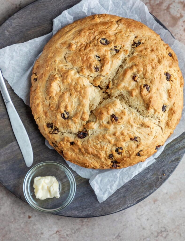 Freshly baked loaf of traditional Irish Soda Bread on a wooden table