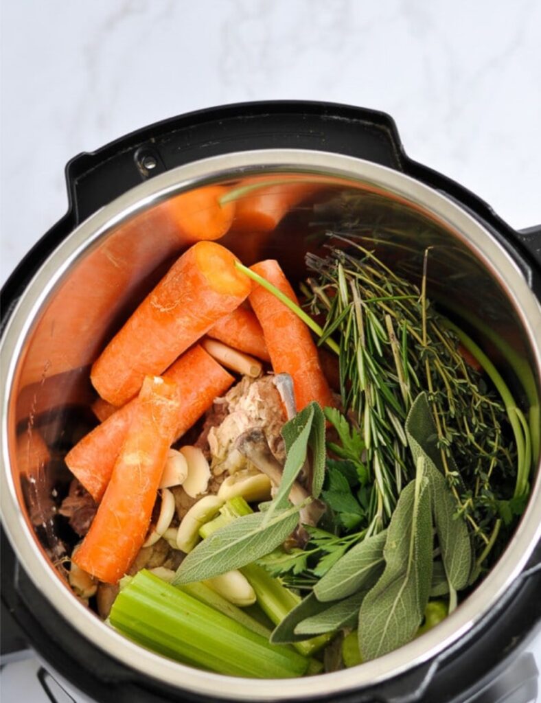 Add the quartered onion, chopped carrots, chopped celery, and smashed garlic to the pot. These vegetables will enhance the flavor of your broth.