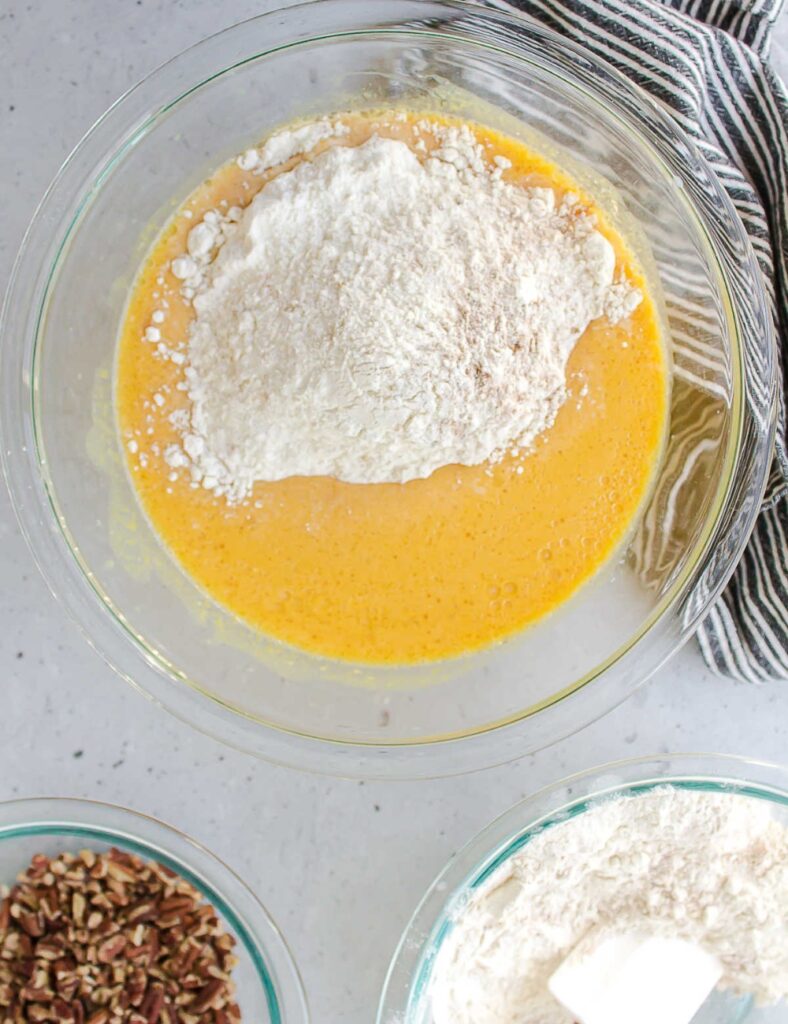 Ingredients for peach cobbler displayed in a bowl, featuring ripe peaches, sugar, and a mix of dry ingredients.
