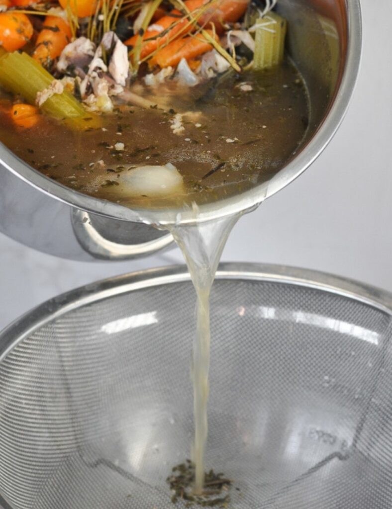 Strain the broth through a fine mesh sieve, discarding the solids to reveal a beautiful, clear liquid.