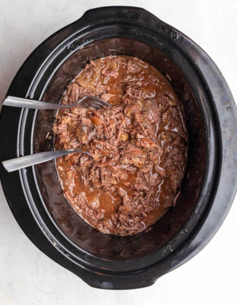 A hearty slow cooker beef stew with tender meat, vegetables, and rich broth, served in a rustic bowl.