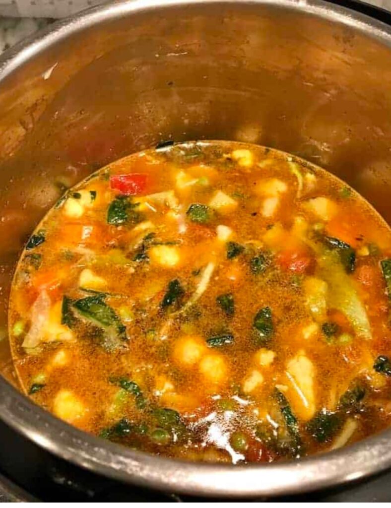 A pot filled with steaming soup and colorful vegetables, showcasing a hearty meal ready to be served.