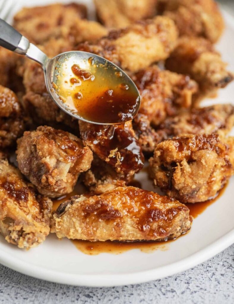 A serving of crispy chicken wings on a plate, showcasing their appetizing texture and color.