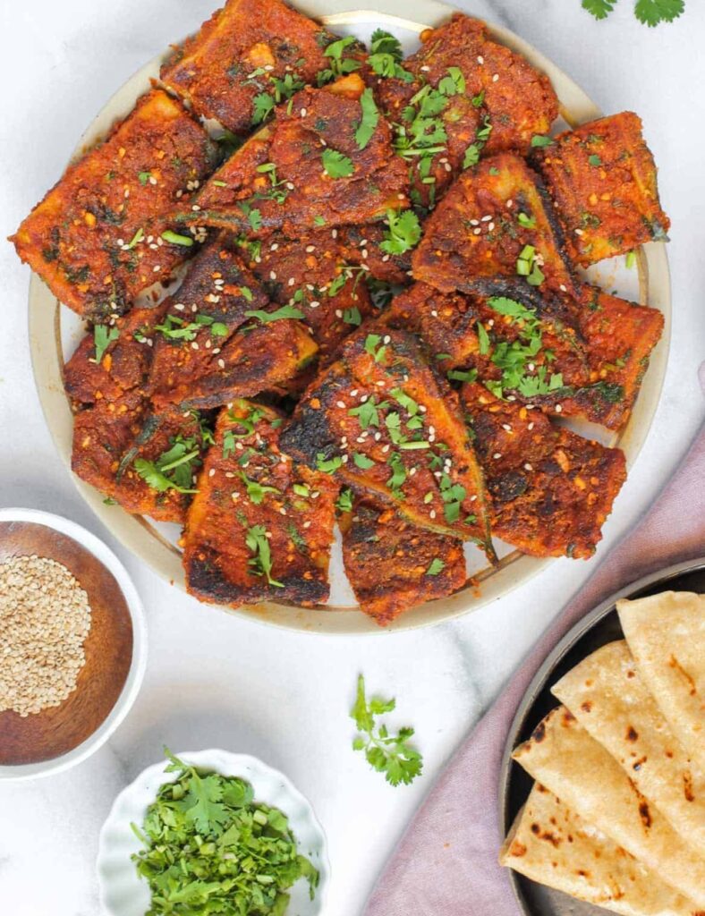 Chicken tikka masala served on a white plate, garnished with cilantro and accompanied by rice and naan.