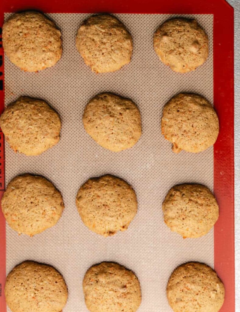 Freshly baked carrot cake cookies with cream cheese frosting and grated carrots