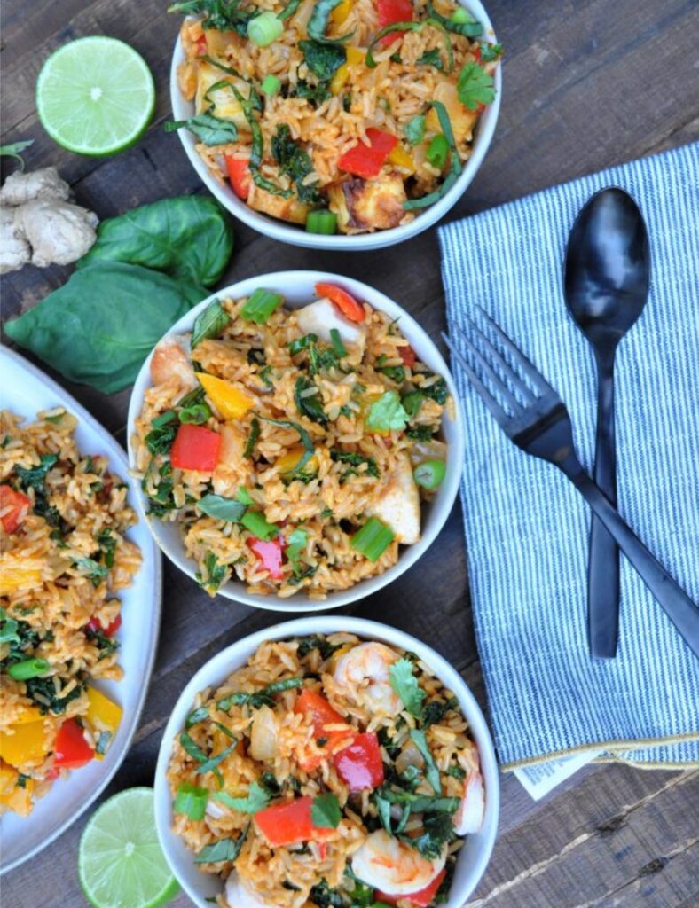 Delicious bowl of Curry Fried Rice garnished with cilantro and spices.