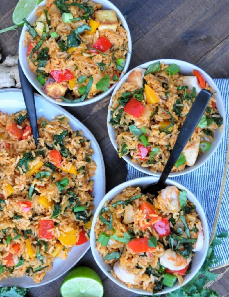 Delicious bowl of Curry Fried Rice garnished with cilantro and spices.