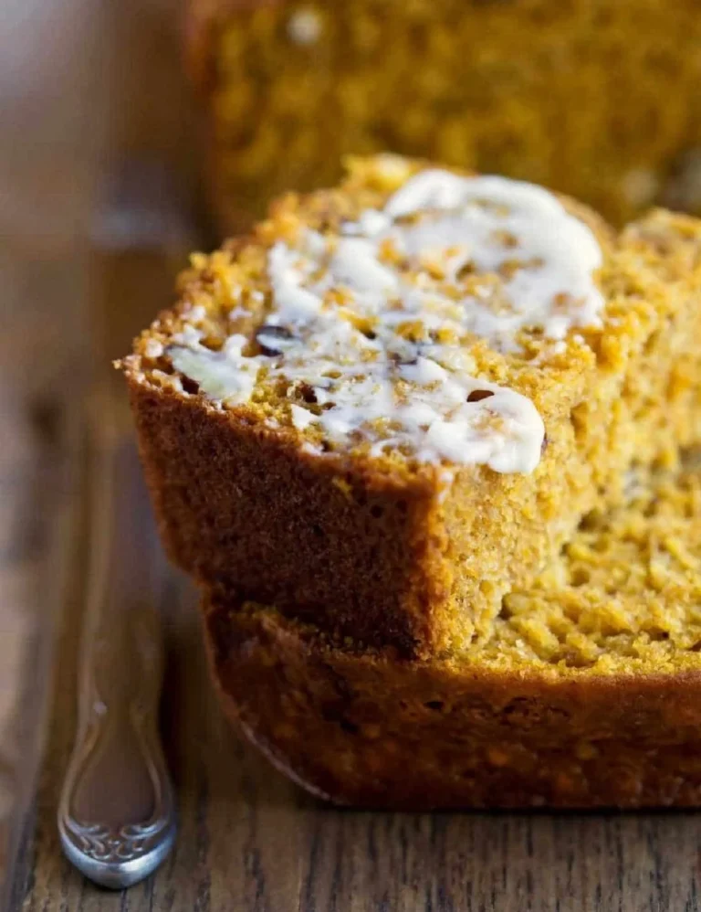 Sliced Buttermilk Pumpkin Spice Bread with spices on a wooden board.