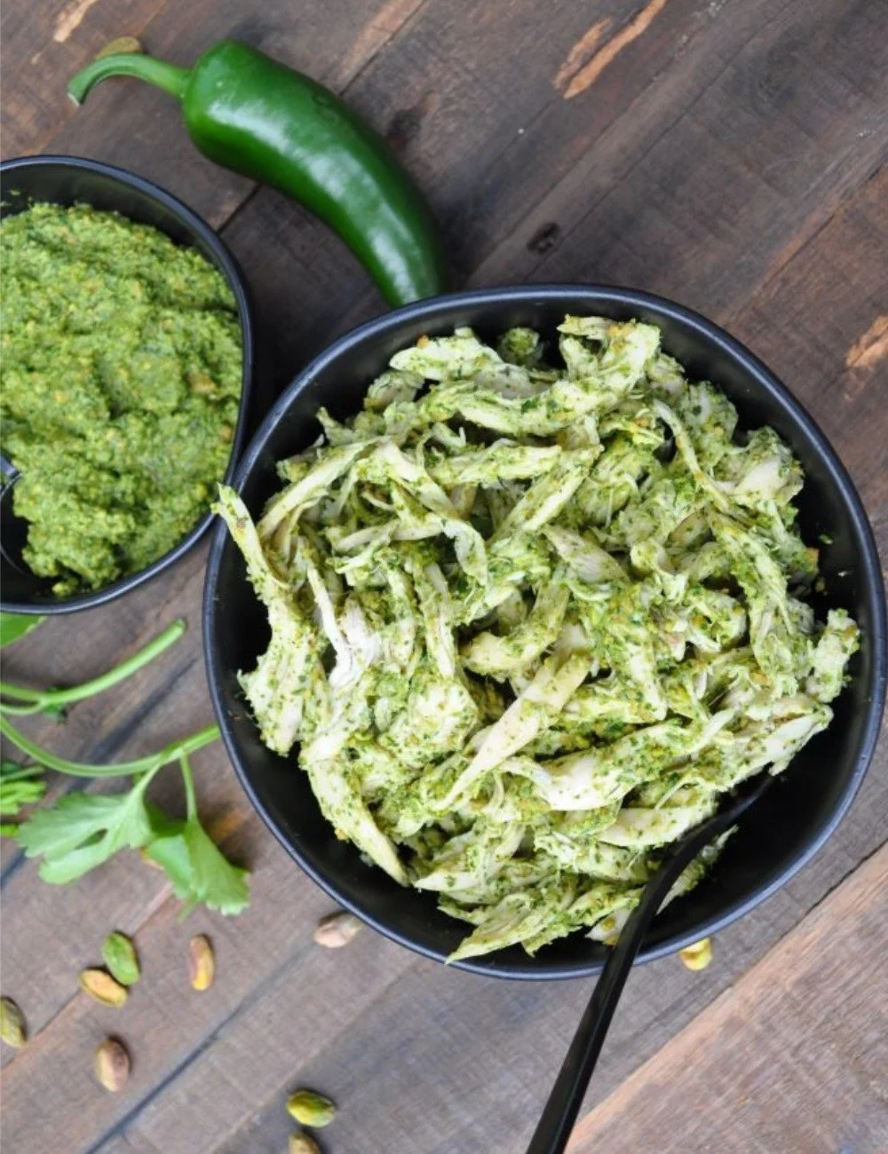 Cilantro pesto chicken salad on a white plate garnished with fresh herbs