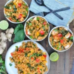 Delicious bowl of Curry Fried Rice garnished with cilantro and spices.