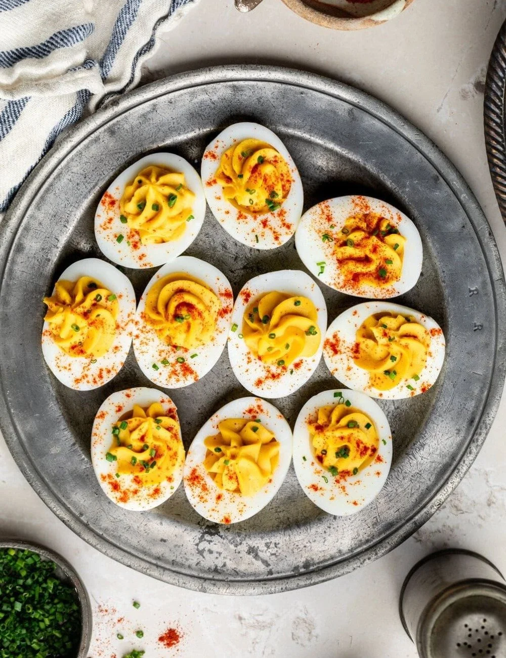 Plate of healthy deviled eggs garnished with herbs
