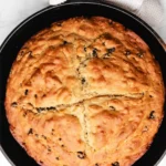 Freshly baked loaf of traditional Irish Soda Bread on a wooden table