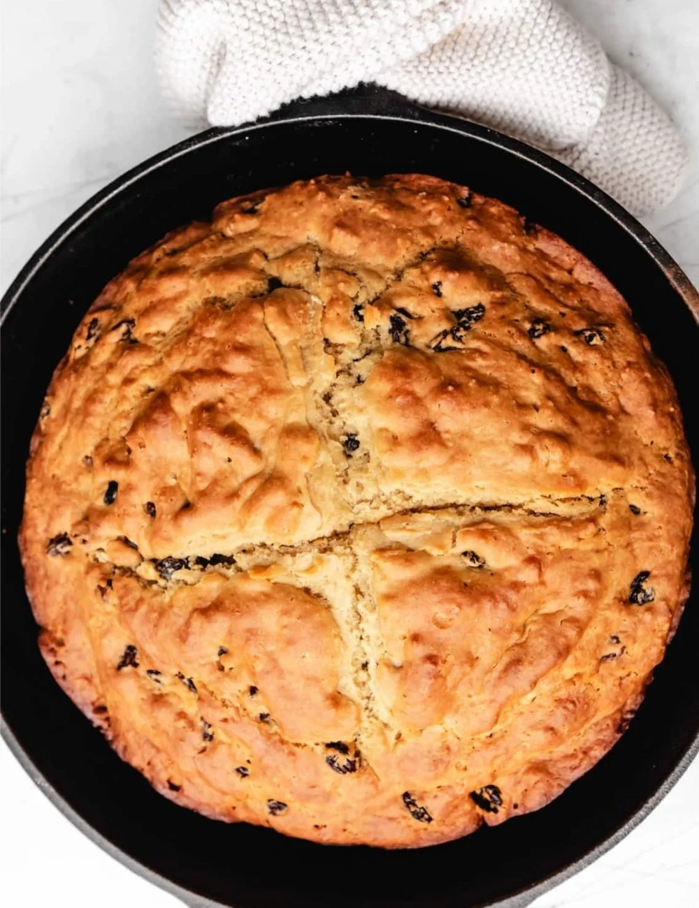 Freshly baked loaf of traditional Irish Soda Bread on a wooden table