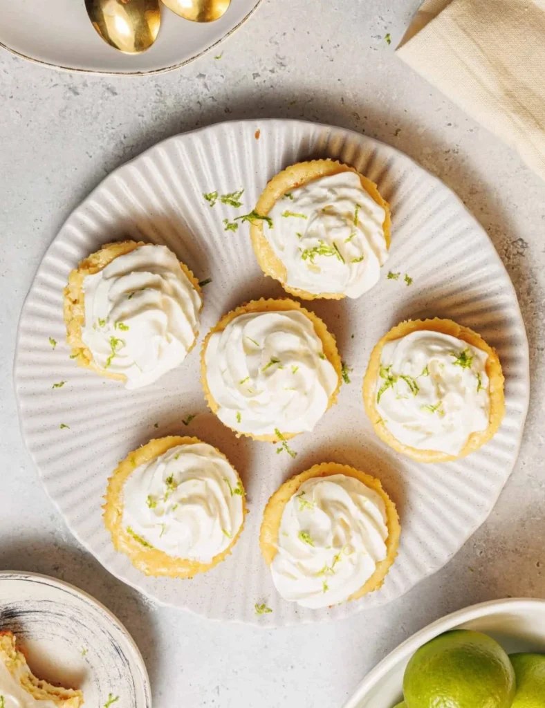 Mini key lime pies with a graham cracker crust and lime garnish