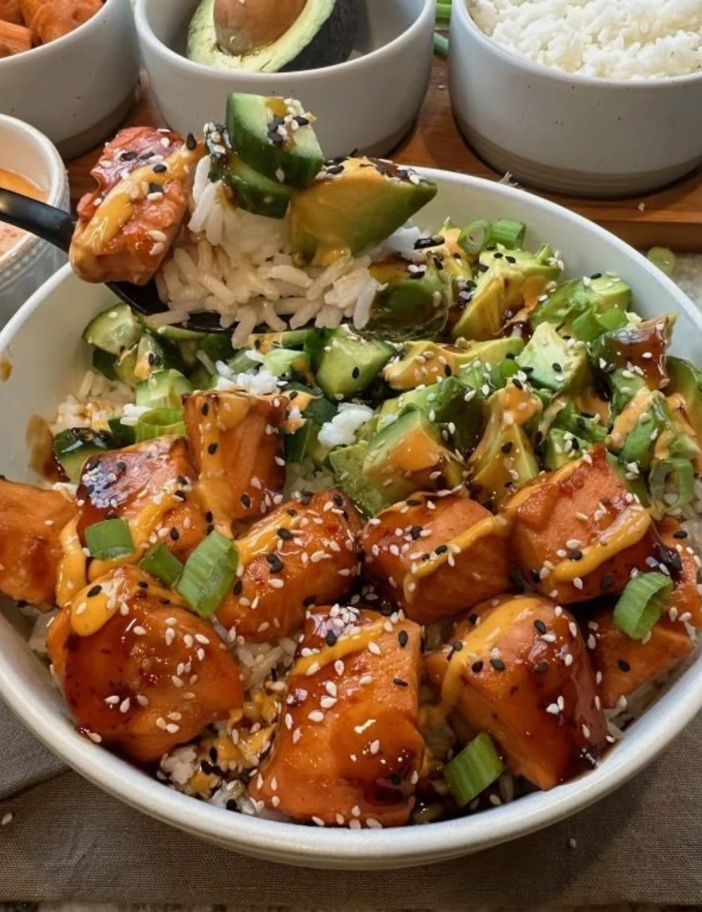A colorful saucy salmon bowl with vegetables and rice