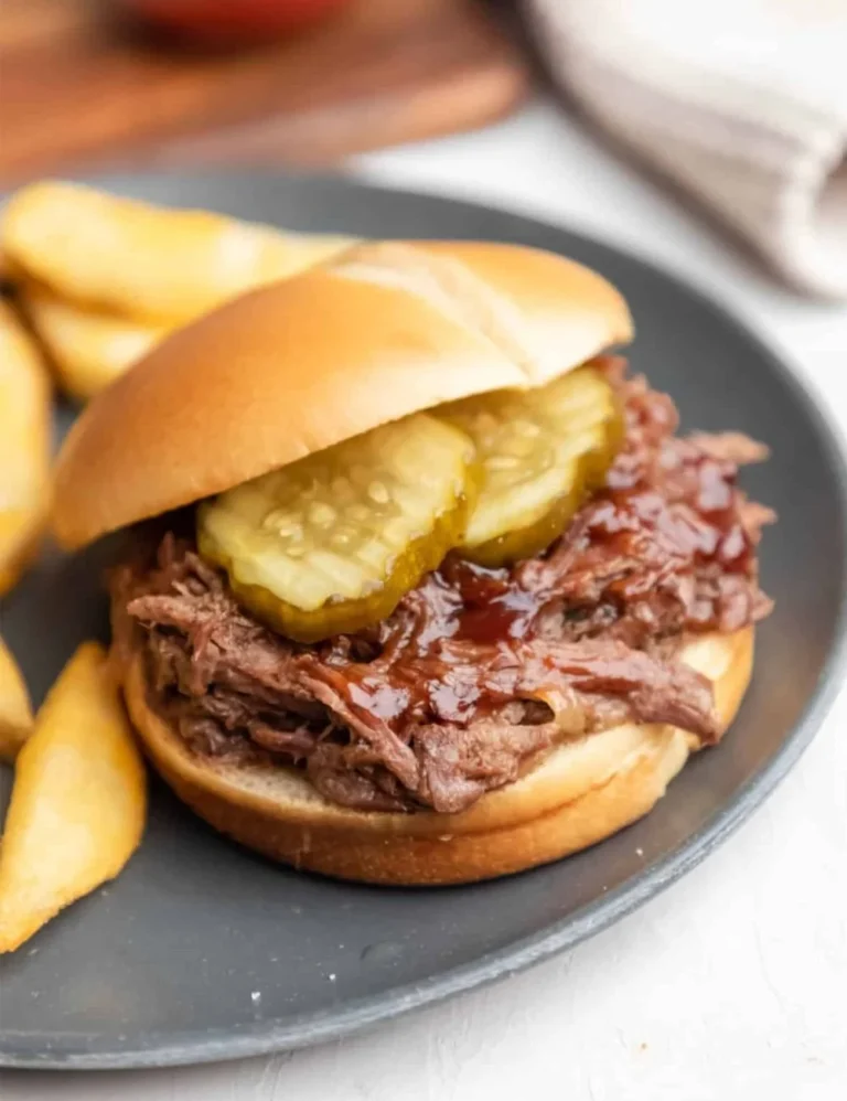 Tender slow cooker barbecue beef served on a plate with a side of coleslaw.