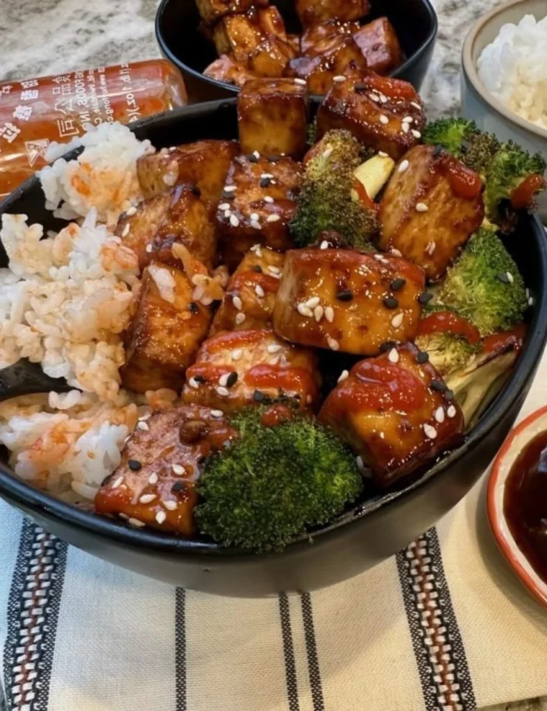 Spicy Sriracha Tofu Bowls garnished with fresh vegetables and herbs