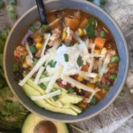 Bowl of hearty and flavorful taco soup topped with cheese and cilantro