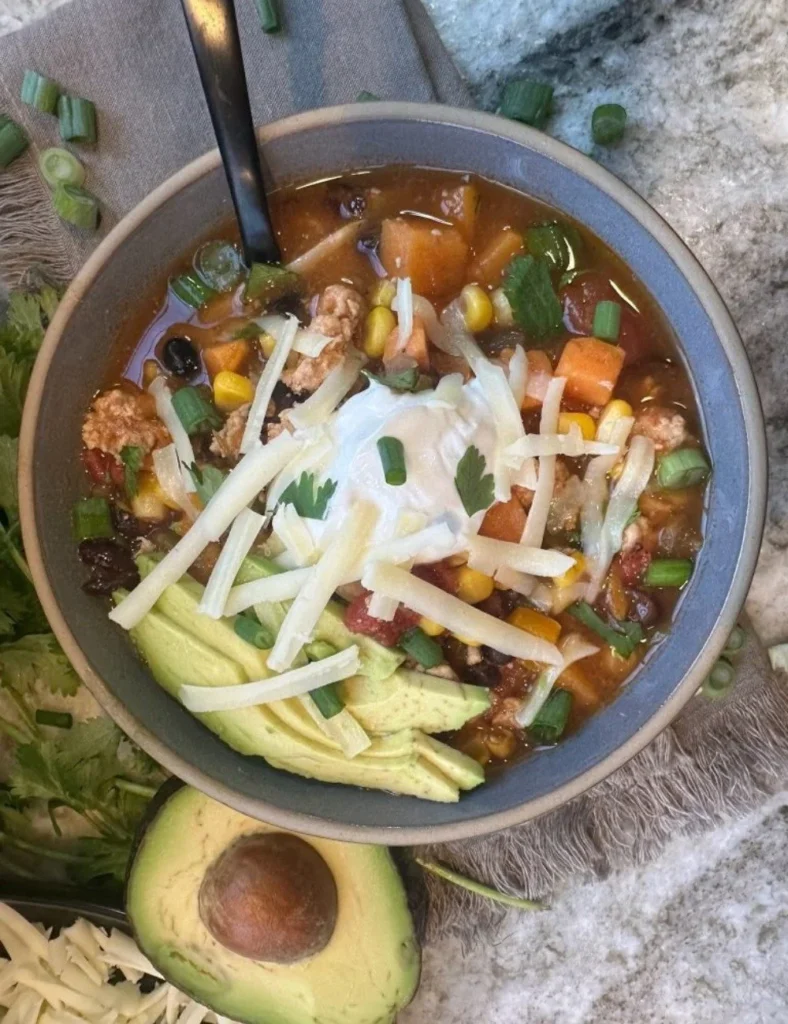 Bowl of hearty and flavorful taco soup topped with cheese and cilantro