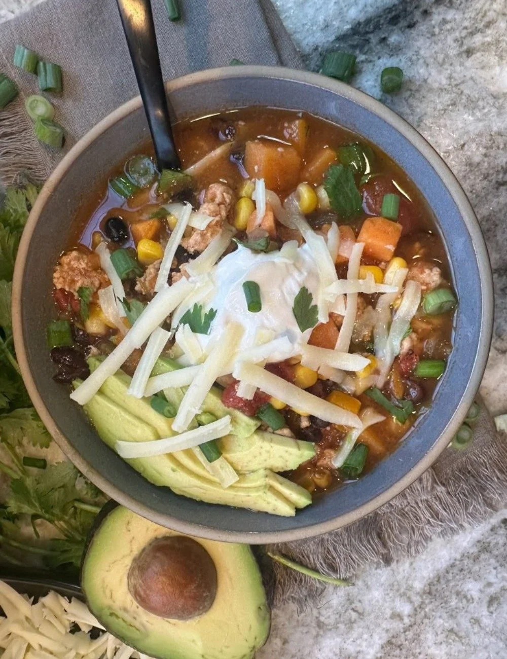 Bowl of hearty and flavorful taco soup topped with cheese and cilantro