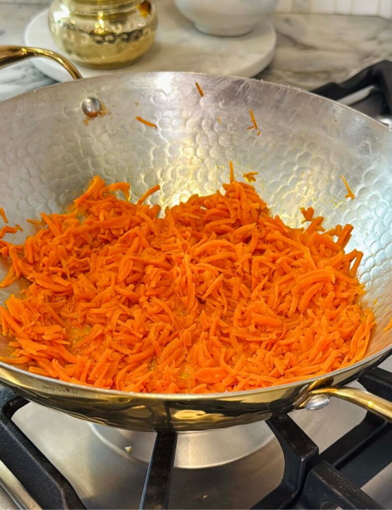 Shredded carrots cooking in pan