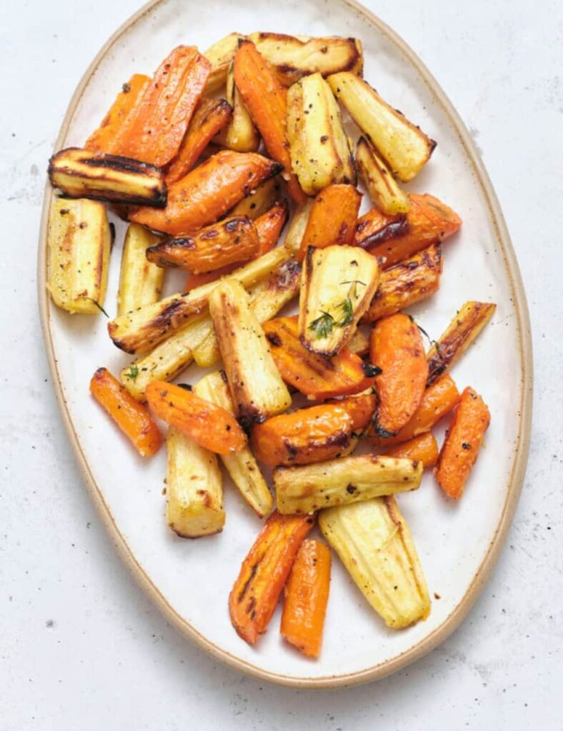 Bowl of roasted carrots and parsnips, vibrant and crispy, ready to serve.
