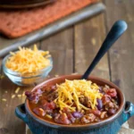 Bowl of hearty barbecue chili topped with fresh cilantro and served with cornbread